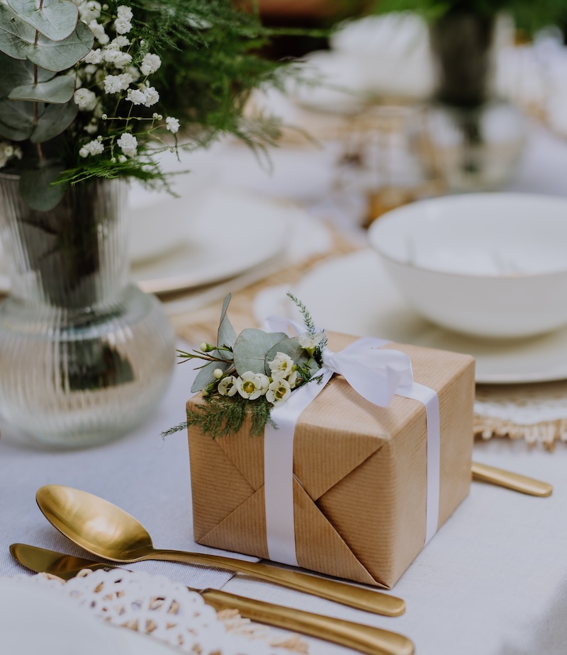 High angle view of wedding gift wrapped in eco paper papckaging and flower decoration.